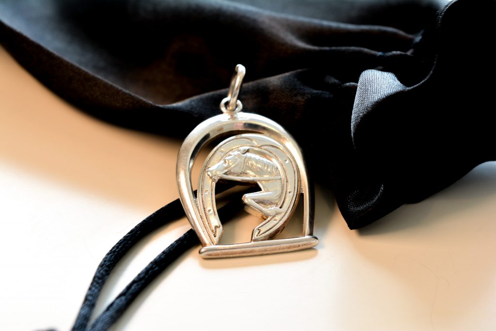 Silver pendant with horse and horse shoe detail