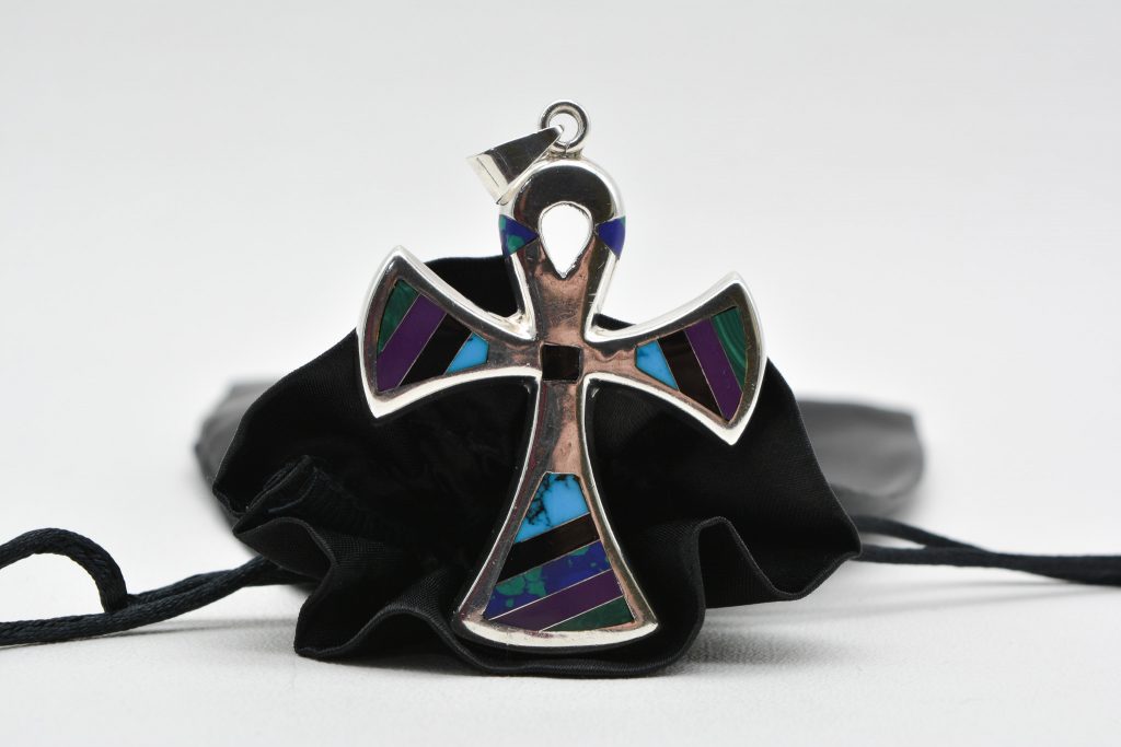 large silver cross with inlaid coloured stones